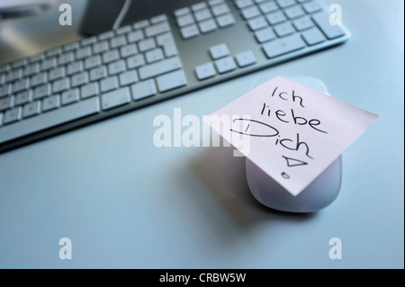 Sticky note with the words 'Ich liebe Dich', German for 'I love you', next to computer keyboard, symbolic image for love at the Stock Photo