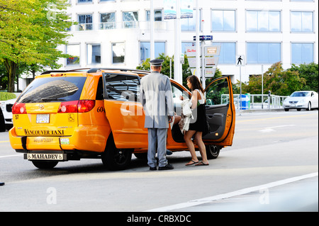 A woman getting into a taxi outside of an in Vancouver. Stock Photo