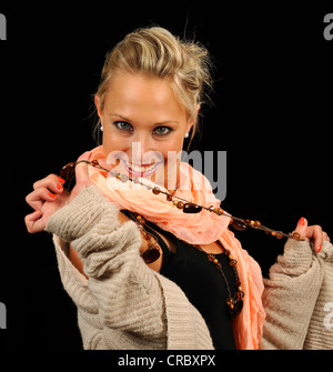 Young woman playfully holding a necklace Stock Photo