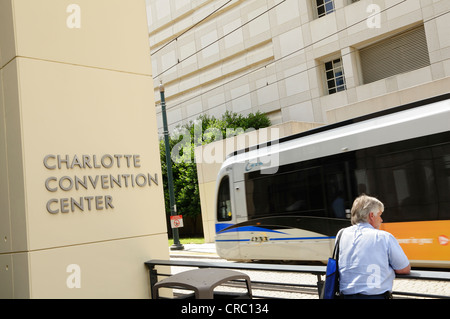 A man standing outside the Charlotte Convention Center looks on as the Lynx light rail train departs for South Charlotte. Stock Photo