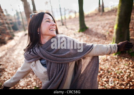 Older woman cheering in forest Stock Photo