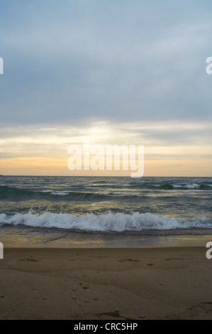 Waves crashing on sandy beach Stock Photo