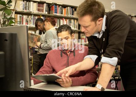 Teacher helping student in library Stock Photo