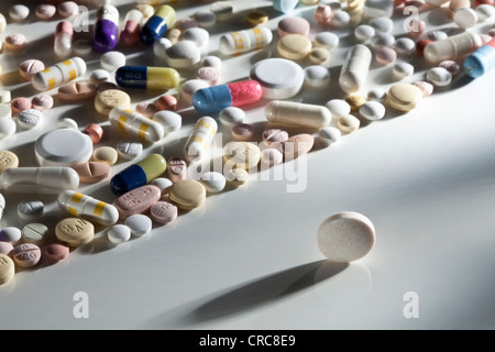 Pills scattered on reflective surface Stock Photo