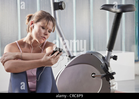 Woman listening to headphones in gym Stock Photo