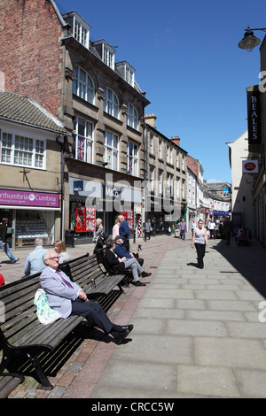 People sitting and walking along Fore Street Hexham Northumberland England UK Stock Photo