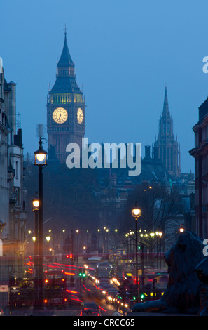 Big Ben clock tower of the Houses of Parliament at night / dusk looking down Whitehall from Trafalgar Square London England UK Stock Photo