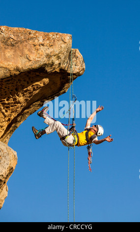 Climber free rappels from the summit after a challenging ascent. Stock Photo