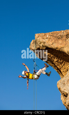 Climber free rappels from the summit after a challenging ascent. Stock Photo