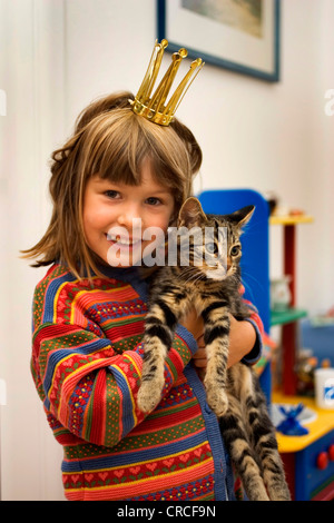 domestic cat, house cat (Felis silvestris f. catus), little girl with crown holding a cat Stock Photo