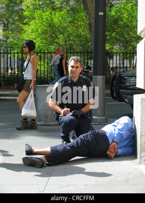 Police officer arresting homeless person, USA, New York City Stock Photo