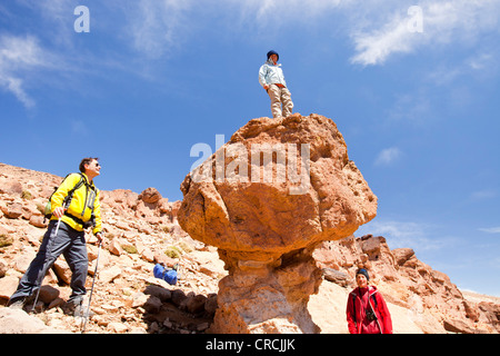 Trekkers in the Anti Atlas mountains of Morocco with a weathered pinnacle of rock. Stock Photo