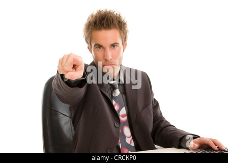 young businessman at his desk, pointing towards camera Stock Photo