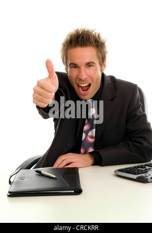 young successful businessman at his desk, making thumb up Stock Photo