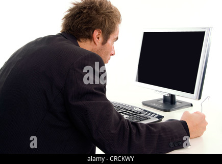 man sitting at a desk in front of a black screen Stock Photo