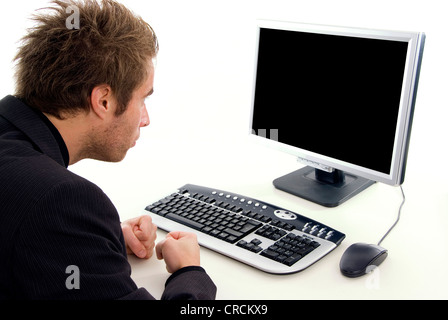 man sitting at a desk in front of a black screen Stock Photo