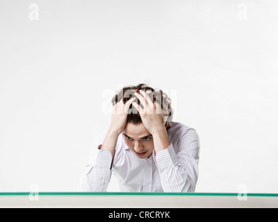Desperate young man at desk Stock Photo