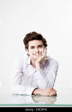Smiling young man at desk Stock Photo
