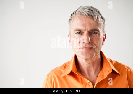Confident mature man wearing orange shirt Stock Photo