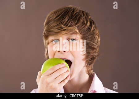 Teenage boy eating an apple, portrait Stock Photo