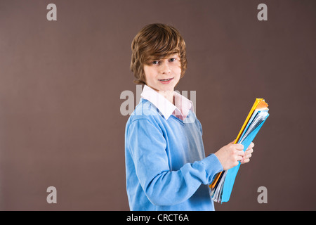 Smiling teenage boy holding folders Stock Photo