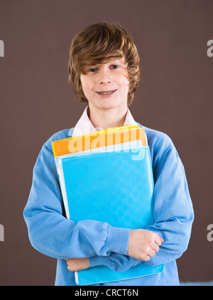 Smiling teenage boy holding folders Stock Photo