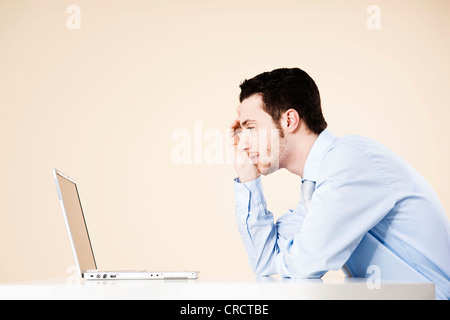 Young man sitting in front of laptop Stock Photo
