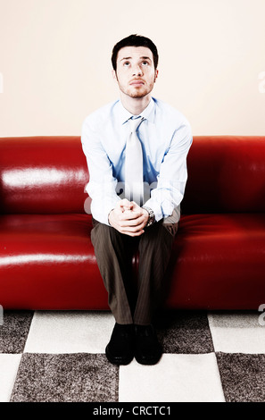 Young man sitting on sofa Stock Photo