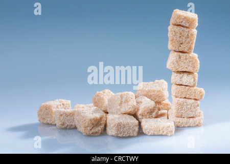Vertical stack of brown sugar cubes on blue. Horizontal. Stock Photo