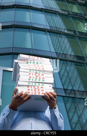 Man with pizza boxes in front of his face Stock Photo