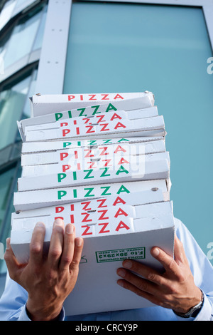 Man with pizza boxes in front of his face Stock Photo