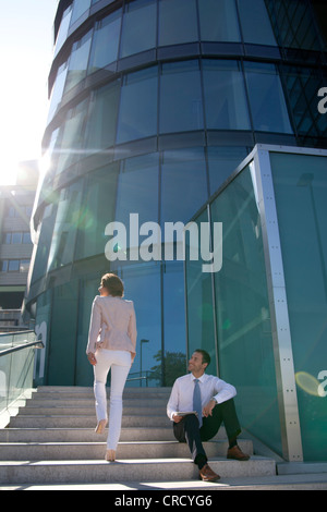 Smiling businessman and businesswoman on stairs Stock Photo