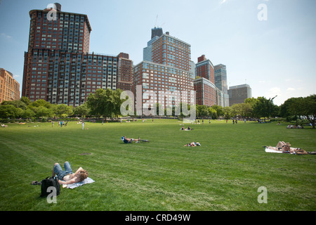 Park goers relax and sunbathe on the lawn at Hudson River Park in New York Stock Photo