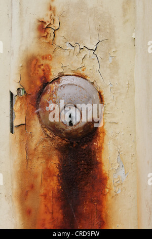 Detail from old door with cracked paint and a rusty lock Stock Photo