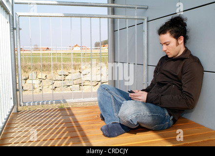 man with mobile on balcony Stock Photo