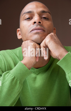 Young man, dark-skinned, head resting on hands, portrait Stock Photo