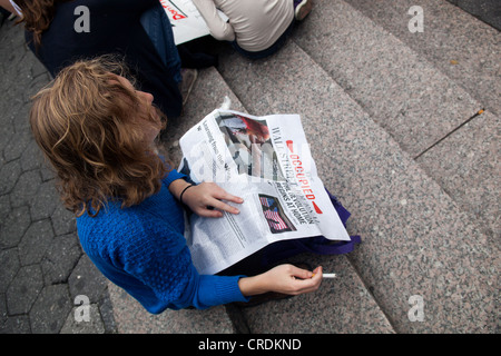 Woman reading Occupied Wall Street Journal in Union Square, New York City. Stock Photo