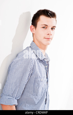 Young man leaning against a wall Stock Photo