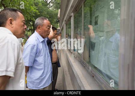 Chinese men reading newspapers, early morning in Zizhuyuan Park, in Beijing, China Stock Photo