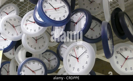 analog wall-clocks hanging down from ceiling Stock Photo