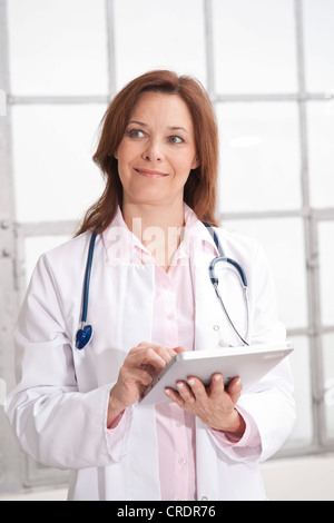 Smiling female doctor using an iPad Stock Photo