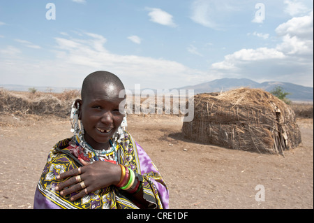 Portrait, ethnology, Maasai woman wearing jewellery, Maasai, bald, shaved head, in front of Hut made of Straw and branches Stock Photo