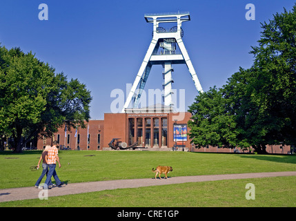 a couple walking with the dog in front of the German Mining Museum, Germany, North Rhine-Westphalia, Ruhr Area, Bochum Stock Photo