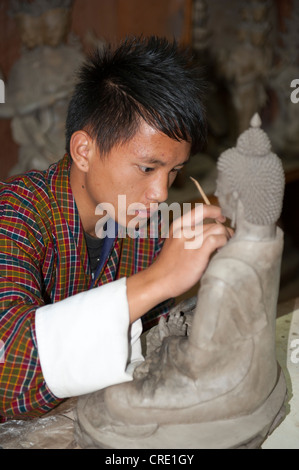Young man training to become a sculptor, working very focused on a small Buddha statue, handicraft, National Institute of Zorig Stock Photo