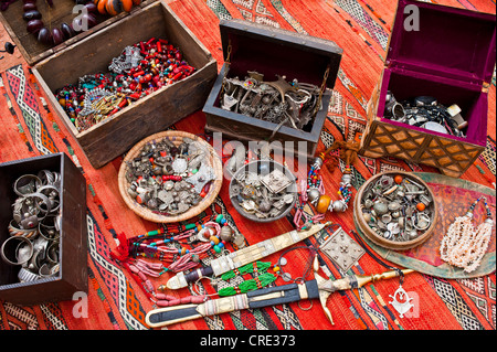 Oriental jewellery, small treasure chests and ornate Touareg knives are spread on a carpet in a souk or bazaar, Morocco, Africa Stock Photo