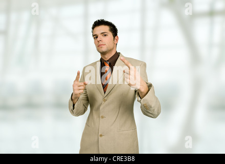 Businessman in a suit pointing up at the office Stock Photo