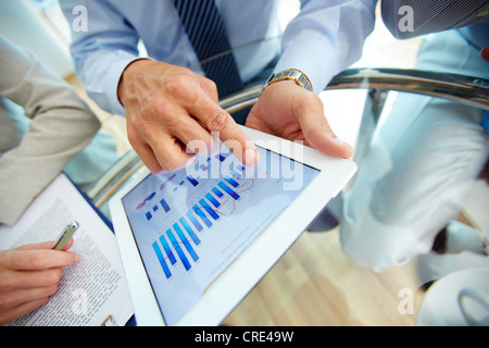 Close-up of a modern business team using tablet computer to work with financial data Stock Photo