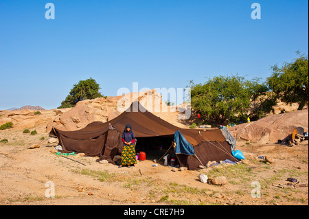 Young Berber woman standing in front of her nomadic tent, Anti-Atlas Mountains, southern Morocco, Africa Stock Photo