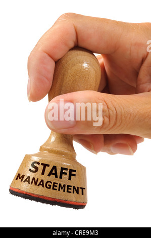 rubber stamp in hand marked with staff management Stock Photo