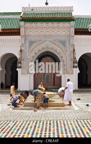 Muslim men cleaning their feet before prayer in the courtyard of Kairouan mosque and university, Medina, Fes, Morocco, Africa Stock Photo